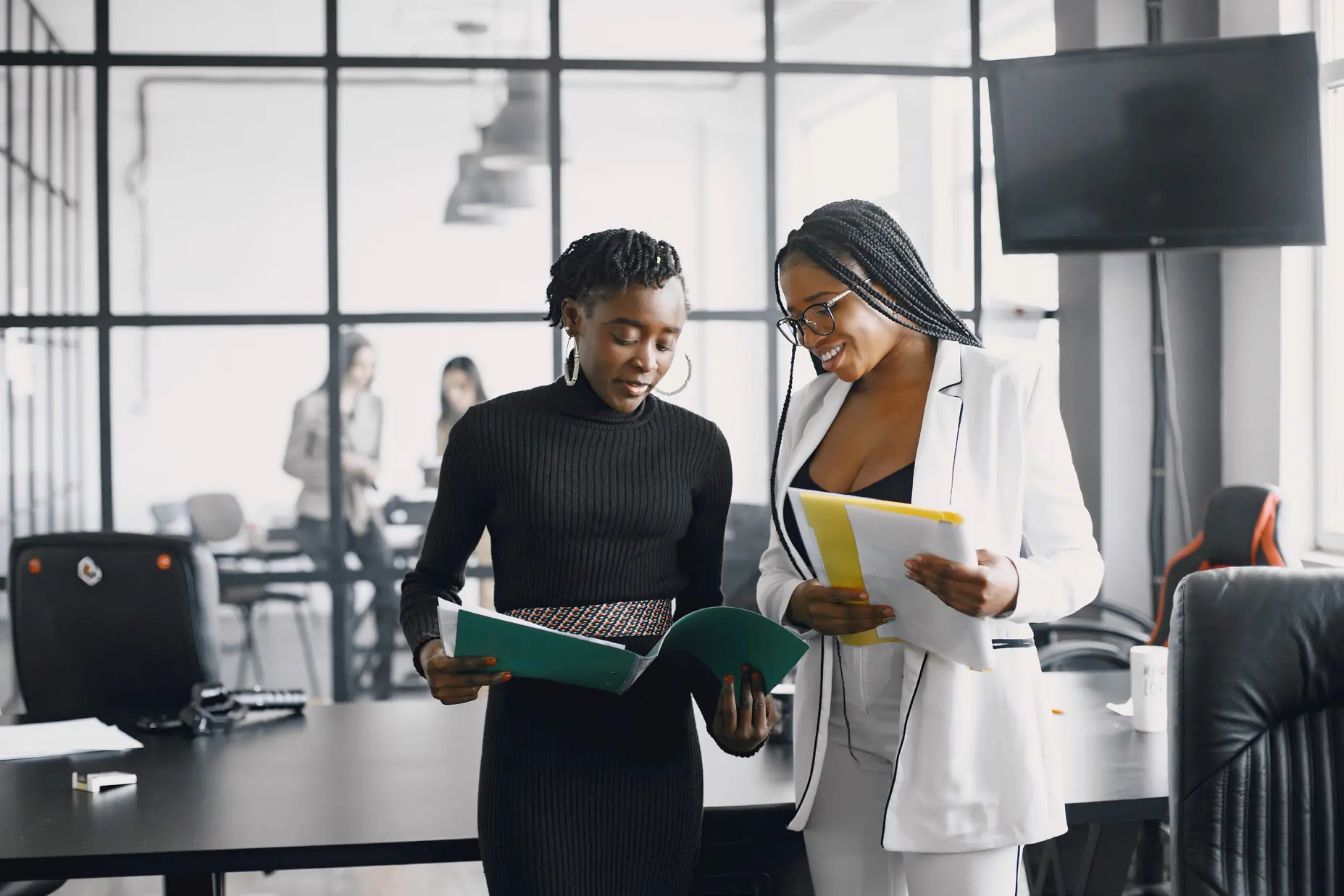 Two women reviewing documents together in a bright office