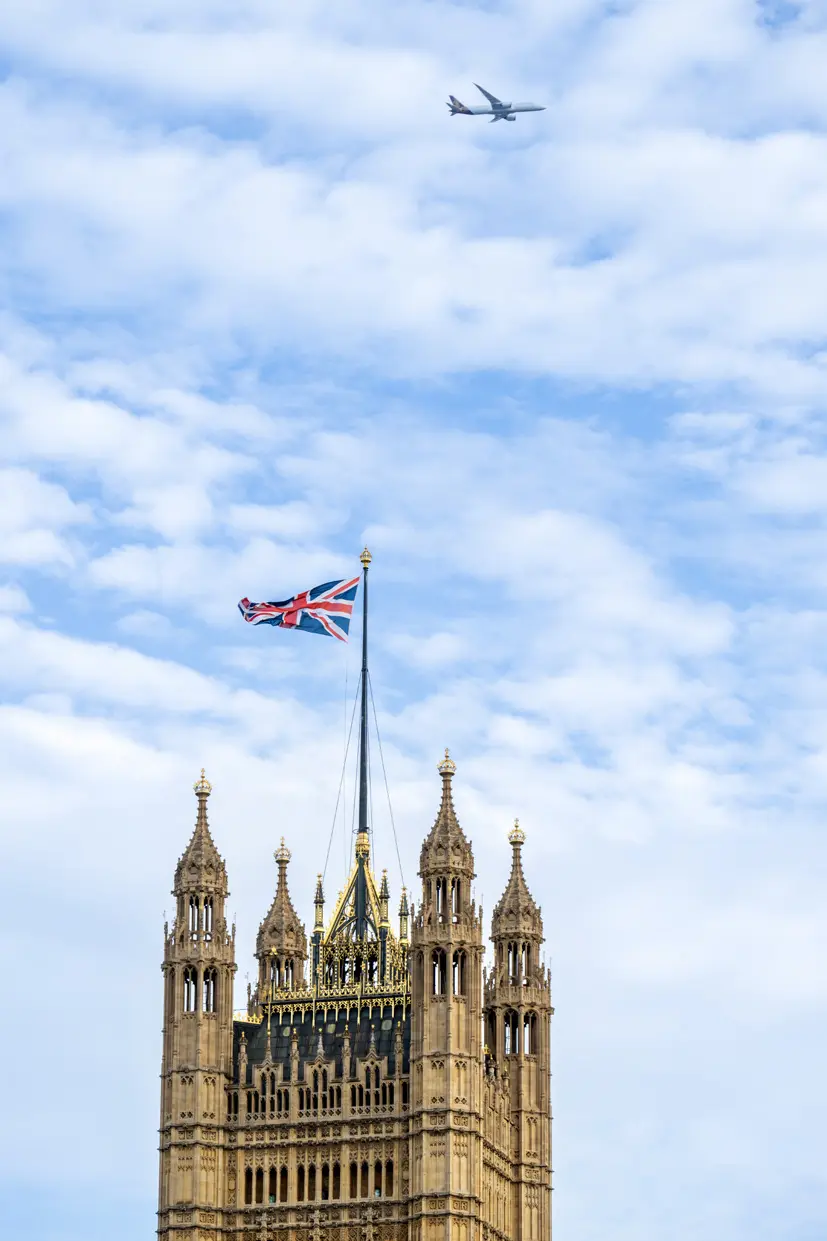 The Palace of Westminster with the Union flag against a blue sky