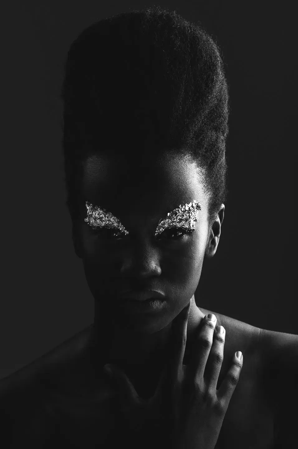 Black and white portrait of a woman with silver leaf over her eyes